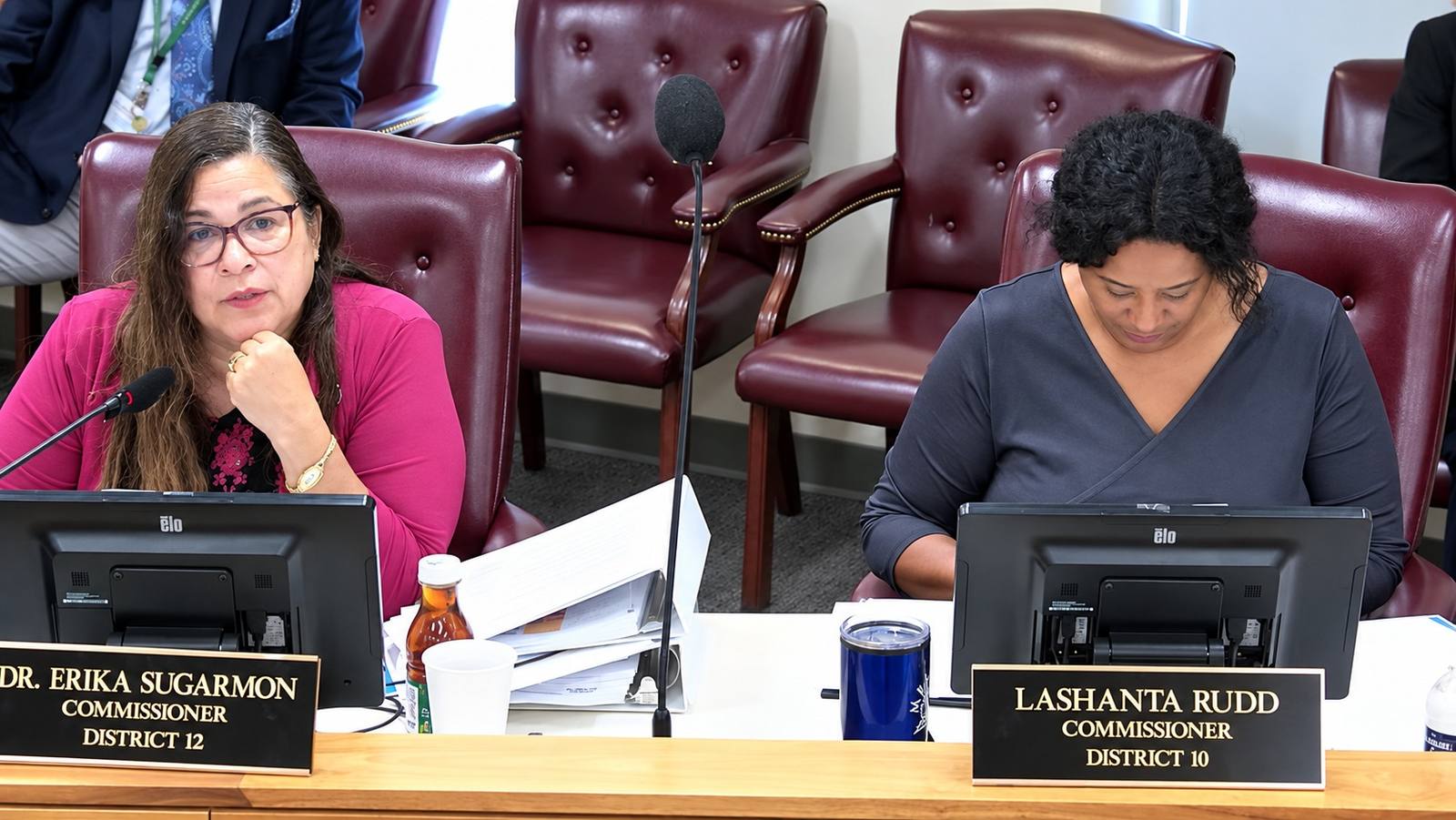 Commissioners Erika Sugarmon and Lashanta Rudd sit at their desks during a Shelby County Commission meeting.