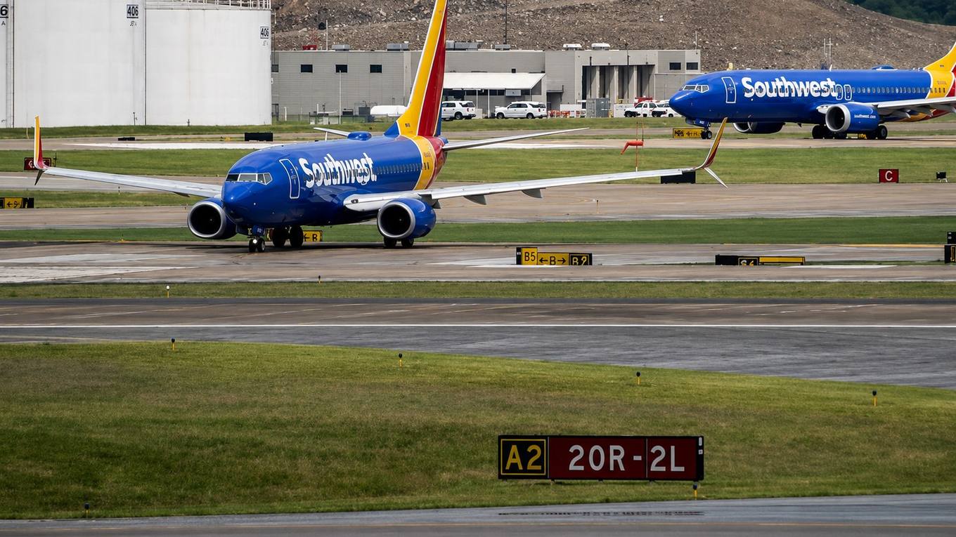 Passenger jets taxiing on airport apron and runway pavement past terminal buildings, representing the airport authorities restructured by state legislation.