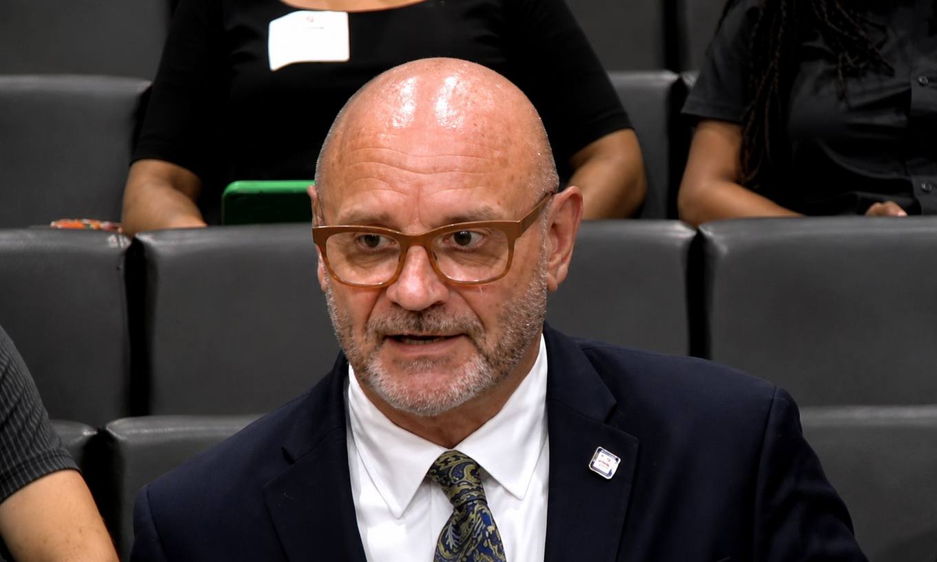 A man in a dark suit and tie speaks during a Memphis City Council meeting.