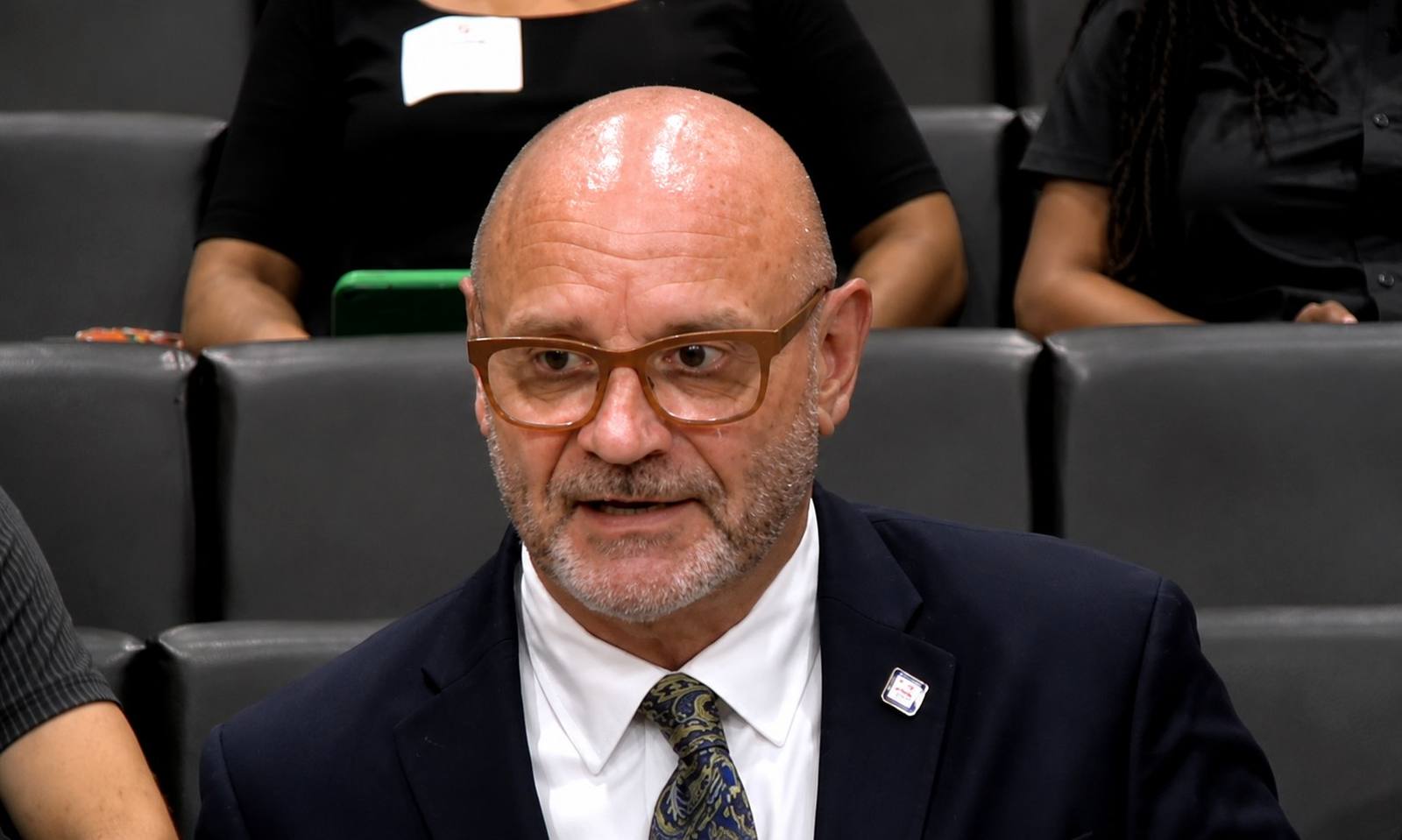 A man in a dark suit and tie speaks during a Memphis City Council meeting.