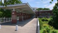 The covered entrance walkway of a suburban public library branch on a sunny day.