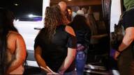 People are escorted into a white van by a federal agent during a nighttime immigration enforcement operation at El Corralon on Macon Road in Memphis.