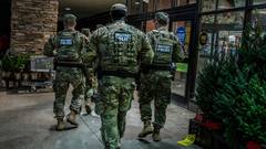 Members of the Tennessee National Guard walk a Memphis storefront sidewalk on patrol.