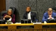 County commissioners seated at the dais during a commission meeting.