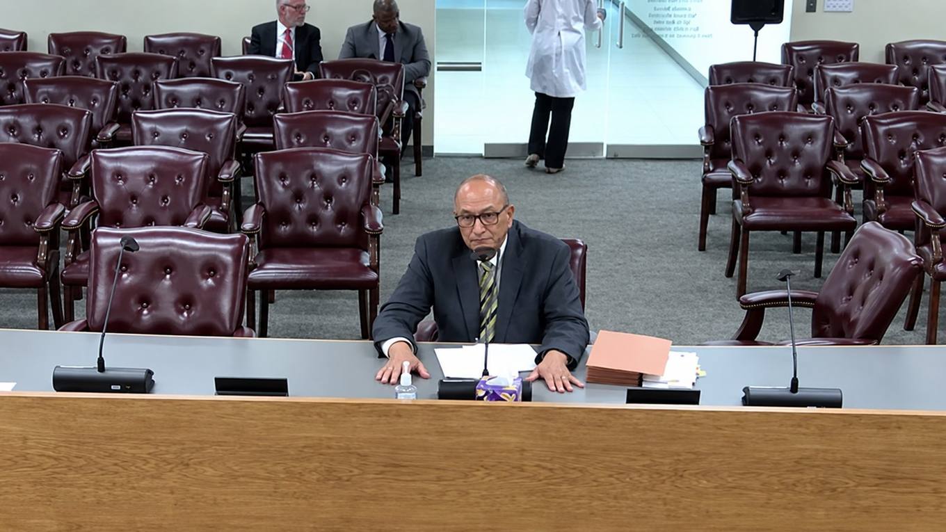 A commissioner in glasses and a grey suit sits at the Shelby County Commission dais during debate over the locally owned small business construction threshold