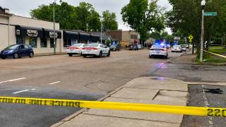 Memphis police cars and yellow police tape blocking a Cooper-Young street near storefronts after a shooting.