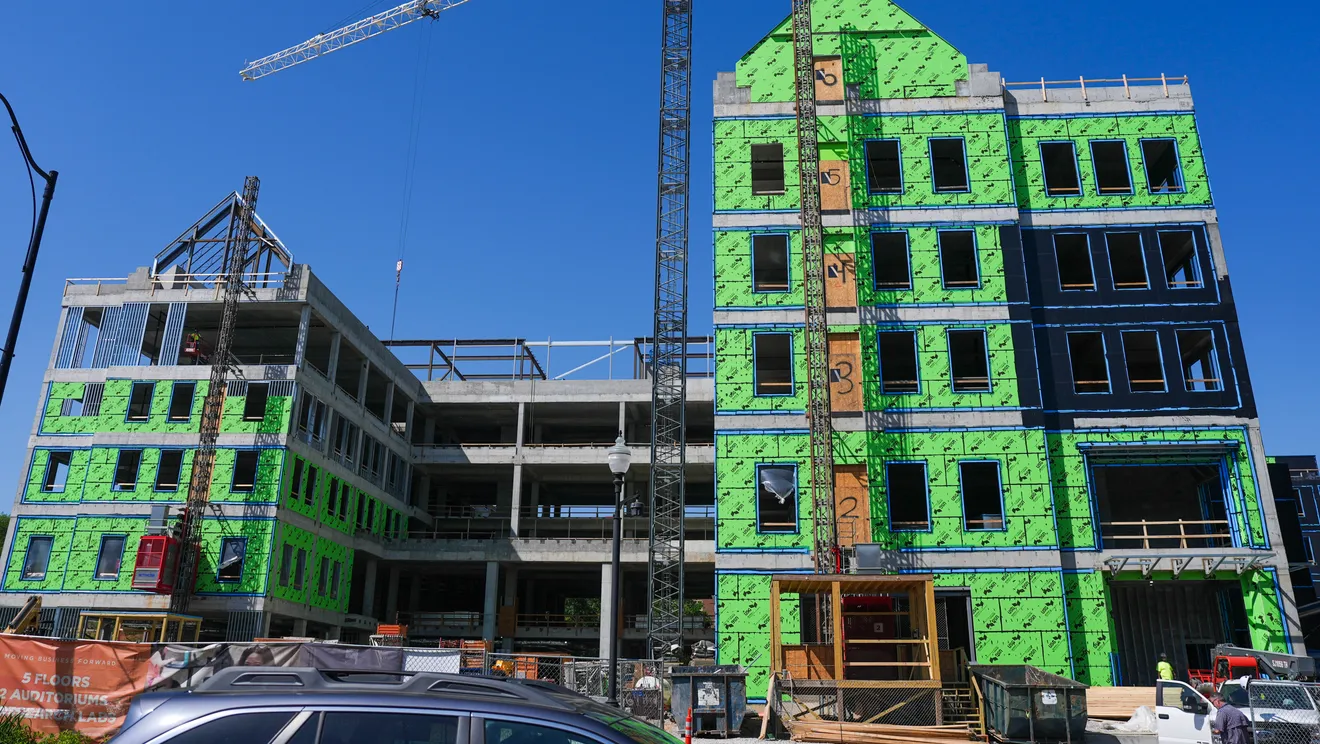 Randy Boyd Hall under construction at the University of Tennessee, Knoxville - a five-story building with green sheathing and a tower crane on a clear day