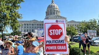 Protesters hold People Not Politicians signs outside the Missouri State Capitol in Jefferson City