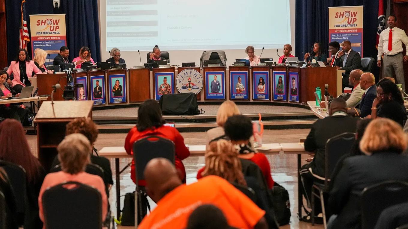Memphis-Shelby County Schools board members seated at a curved dais during a public meeting, with an audience seated in rows in the foreground.