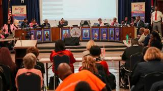 Memphis-Shelby County Schools board members seated at a curved dais during a public meeting, with an audience seated in rows in the foreground.
