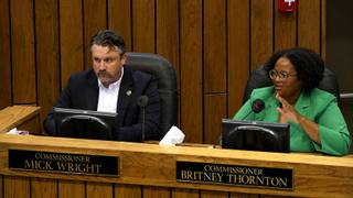 Two Shelby County commissioners seated at the dais during a commission meeting, one speaking into a microphone.