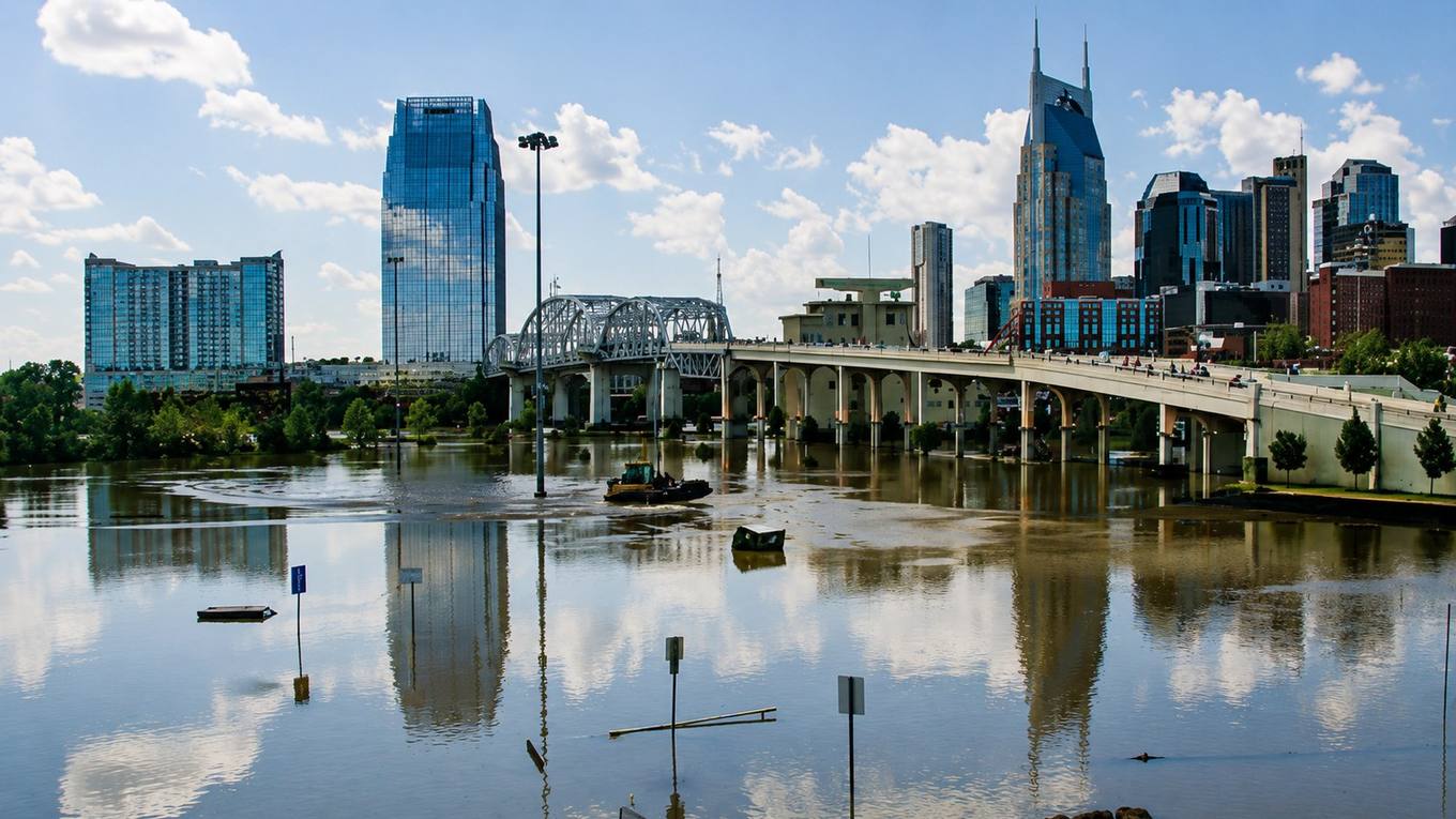 The Nashville skyline seen across the Cumberland River with a bridge in the foreground.