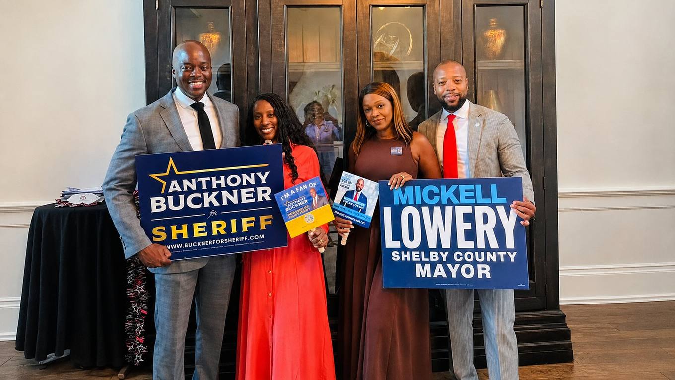 Shelby County Sheriff-elect Anthony J. Buckner and Mayor-elect Mickell M. Lowery hold campaign signs with Chrystal Buckner and Chonisa Lowery at an indoor reception.
