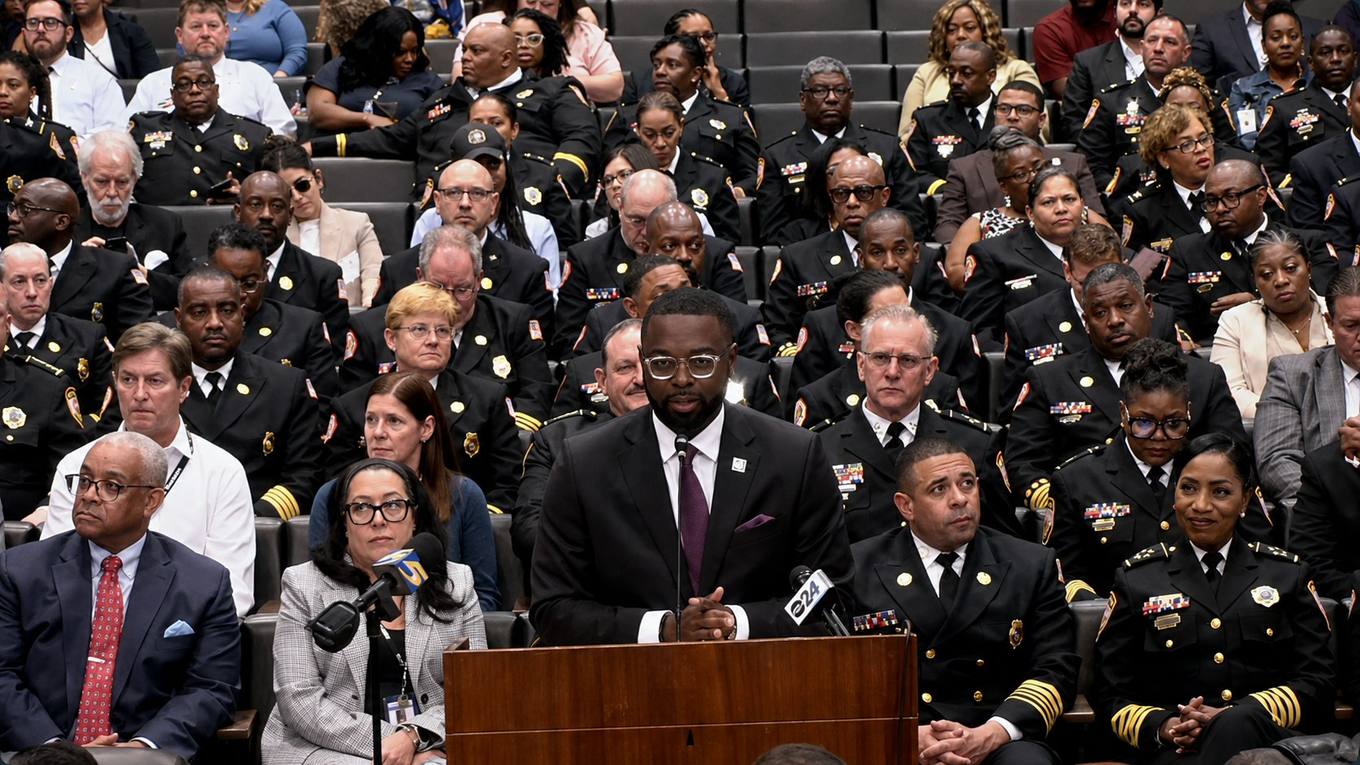 Memphis Mayor Paul Young addresses a City Council budget hearing surrounded by uniformed police and fire leadership.
