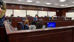 Prince George's County Council members seated at the dais inside the council chamber, with staff seated in the foreground.
