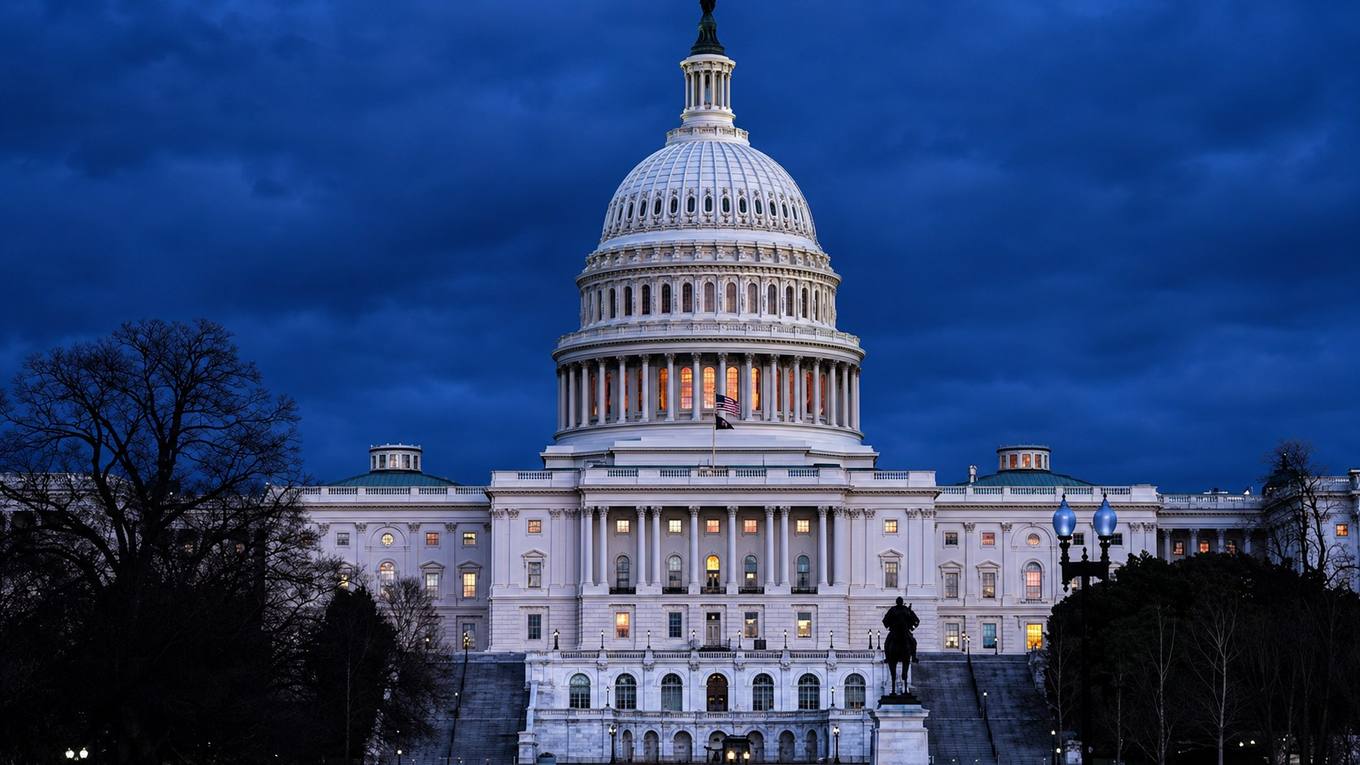 The United States Capitol dome at dusk with interior lights glowing.