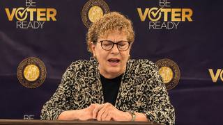 Shelby County Administrator of Elections Linda Phillips speaks at a podium in front of a Shelby County Election Commission backdrop.