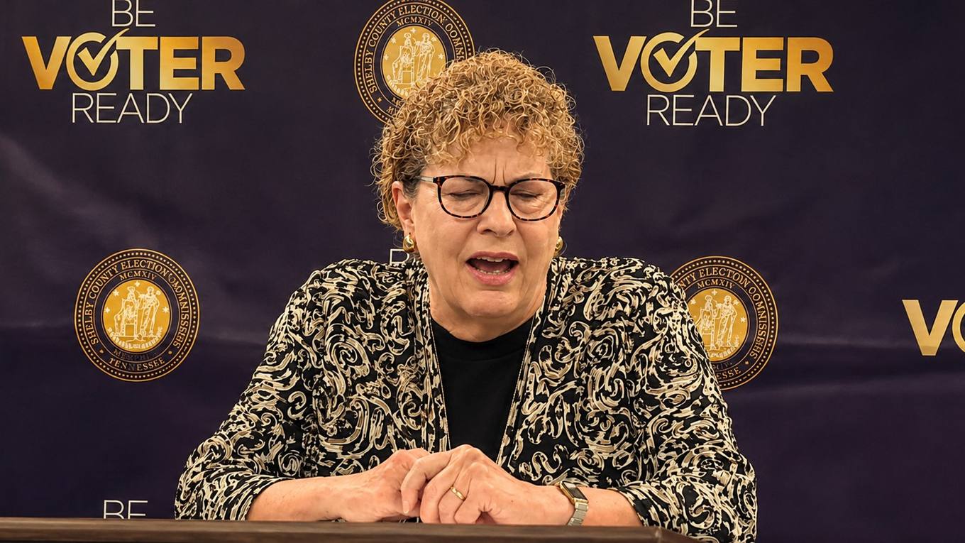 Shelby County Administrator of Elections Linda Phillips speaks at a podium in front of a Shelby County Election Commission backdrop.