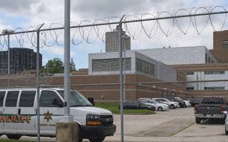 A large concrete institutional building exterior under overcast light, representing the county jail facility named in the lawsuit.