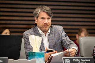 Councilman Philip Spinosa seated at the Memphis City Council dais with a microphone and papers in front of him during a council meeting.