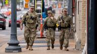Members of the Tennessee National Guard walk along a Memphis street while supporting the Memphis Safe Task Force.