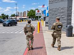 Two National Guard members walk outside a retail store beside a parking lot in Memphis.
