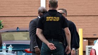 Officers in plainclothes and tactical vests marked Memphis Police Auto Theft Task Force stand outside a brick building in Memphis.