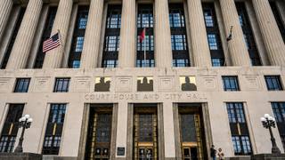 The columned facade of a Tennessee court house and city hall building, with United States, Tennessee and city flags flying above the entrance.