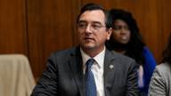 Tennessee Attorney General Jonathan Skrmetti seated at a wood-paneled hearing room table.