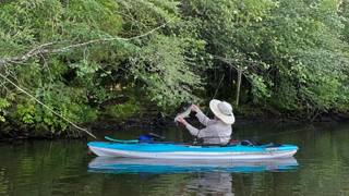 A fisherman holds his catch while fishing on a Tennessee lake.
